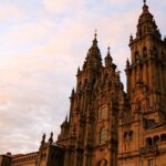 La Catedral de Santiago de Compostela al atardecer, meta final de la Ruta del Románico de peregrinación, destacando su fachada barroca.