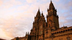 La Catedral de Santiago de Compostela al atardecer, meta final de la Ruta del Románico de peregrinación, destacando su fachada barroca.