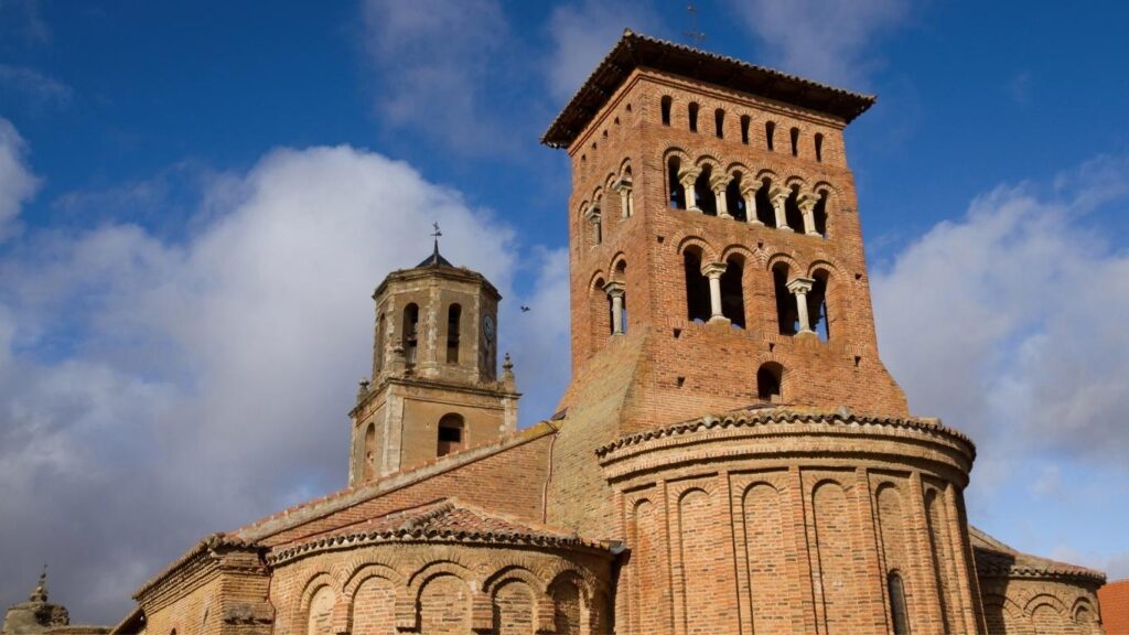 La icónica torre y cabecera de ladrillo de la Iglesia de San Tirso en Sahagún, considerada la cuna del mudéjar castellano.