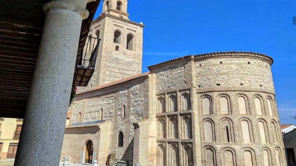 La fachada de la Iglesia de Santa María la Mayor en Arévalo, destacando su galería porticada y el uso estructural del ladrillo mudéjar.