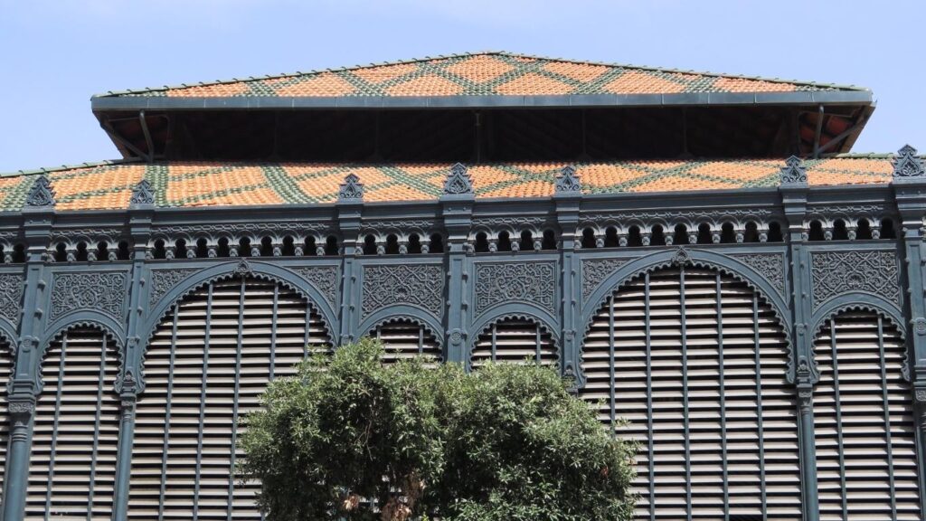 Detalle de la fachada del Mercado de Atarazanas en Málaga, con grandes arcos de herradura de estilo nazarí y una estructura de hierro.