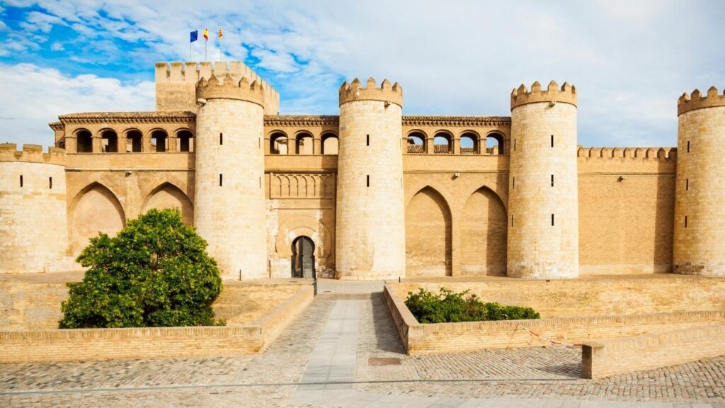 Fachada exterior y torres de piedra y ladrillo del Palacio de la Aljafería en Zaragoza, importante monumento del mudéjar aragonés.