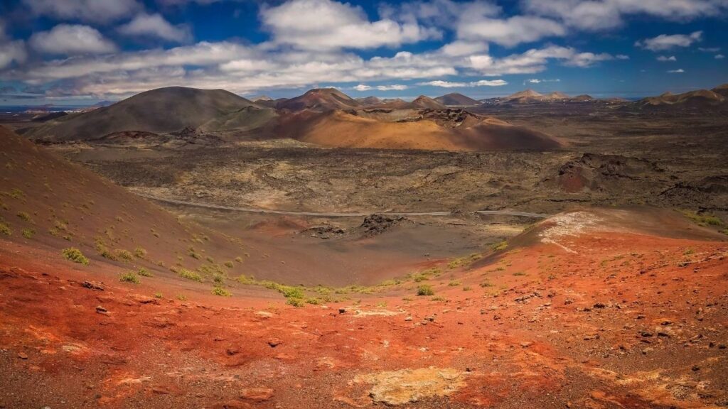 Paisaje desértico y volcánico de tonos rojos y marrones en el Parque Nacional de Timanfaya, Lanzarote.