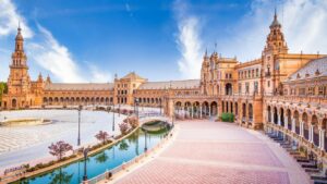 Vista frontal de la portada principal de la Plaza de España en Sevilla, con el canal y el puente.