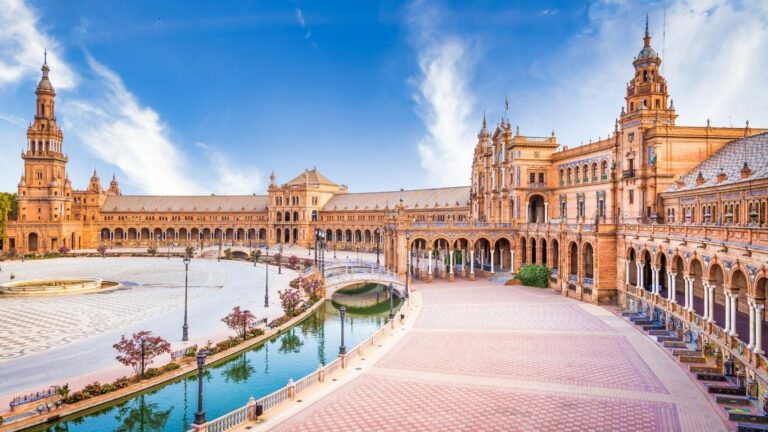 Vista frontal de la portada principal de la Plaza de España en Sevilla, con el canal y el puente.