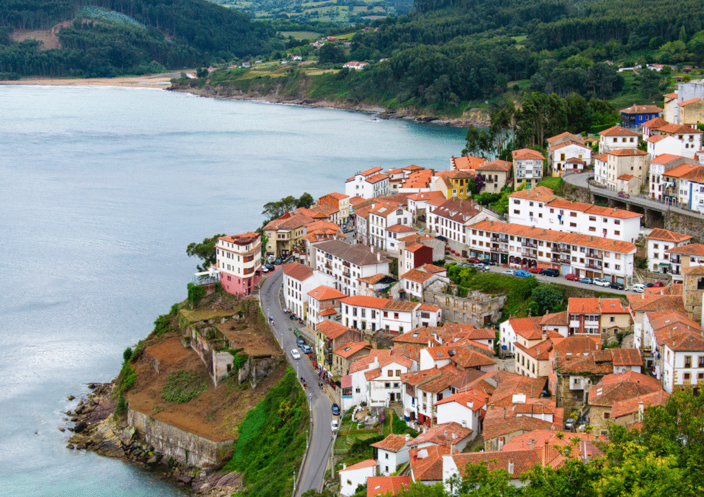 Vista del pueblo de Lastres en Asturias, con sus casas blancas escalonadas sobre la ladera y el mar Cantábrico al fondo, Asturias en invierno.