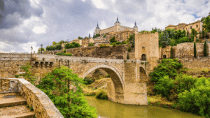 Antiguo puente romano sobre el río Tajo con la Torre del Viento. Una de las 24 paradas esenciales que ver en Toledo.