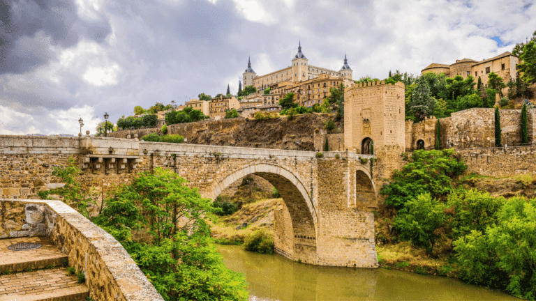 Antiguo puente romano sobre el río Tajo con la Torre del Viento. Una de las 24 paradas esenciales que ver en Toledo.