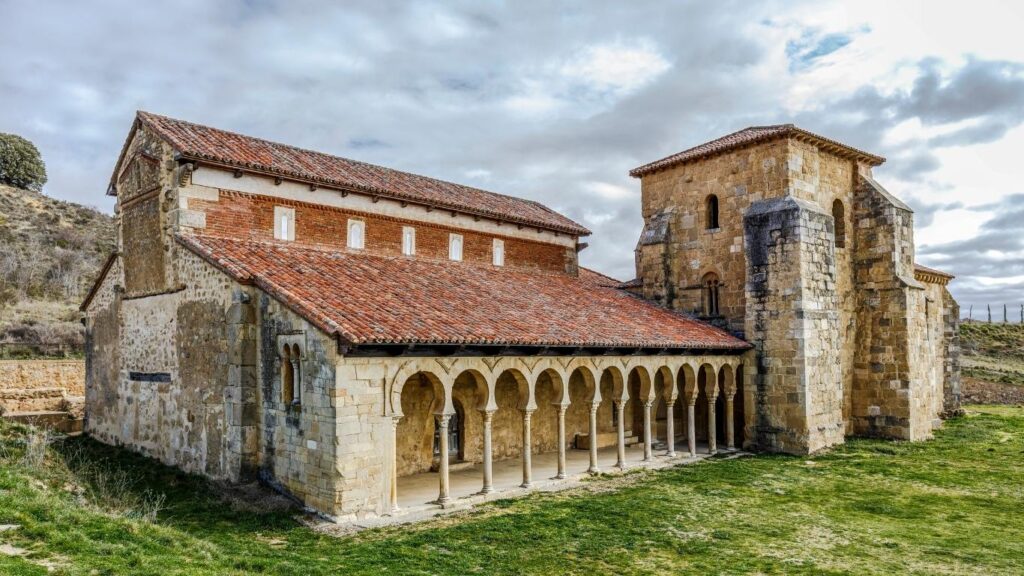 Exterior de la Iglesia de San Miguel de Escalada en León, destacando su pórtico mozárabe de arcos de herradura, un tesoro prerrománico en la Ruta del Románico