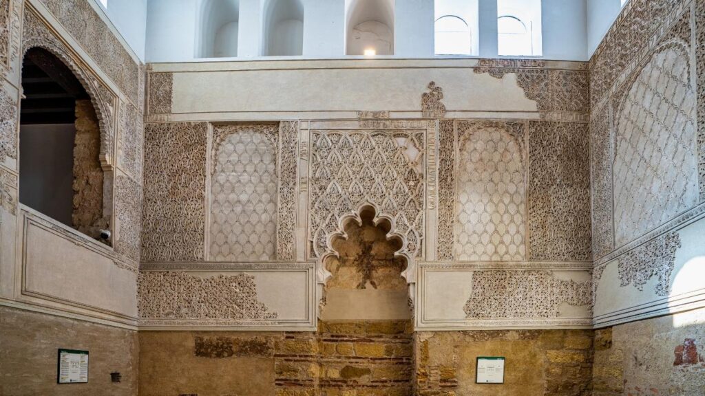 Interior de la Sinagoga de Córdoba con la pared cubierta de yeserías y motivos geométricos del arte mudéjar.