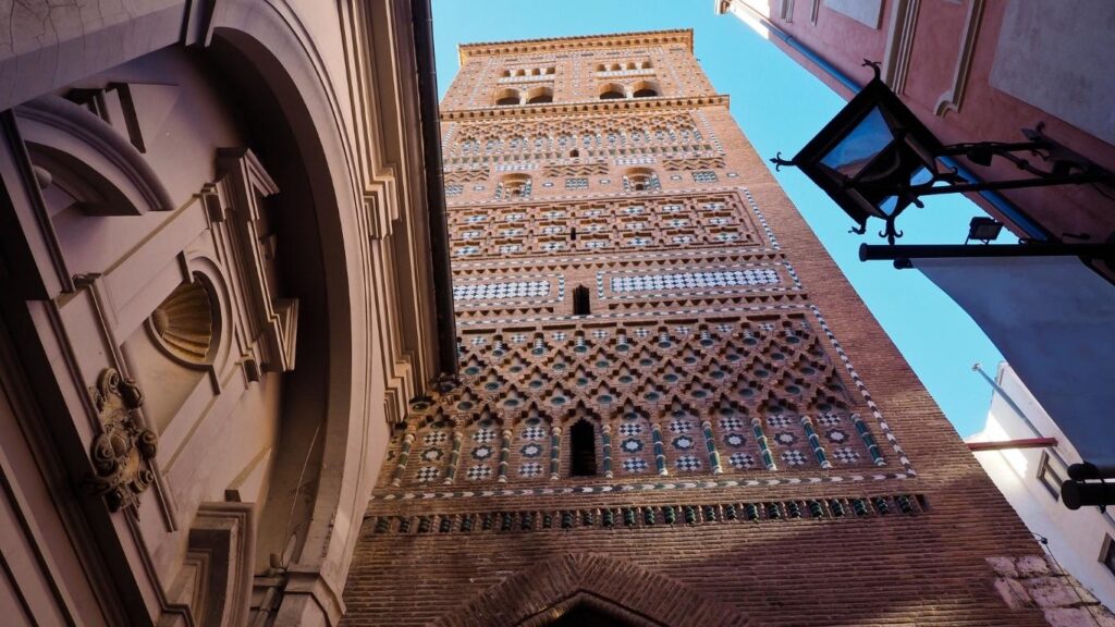 Vista en contrapicada de la Torre de El Salvador en Teruel, con decoración de ladrillo y paneles de cerámica vidriada, Patrimonio UNESCO.