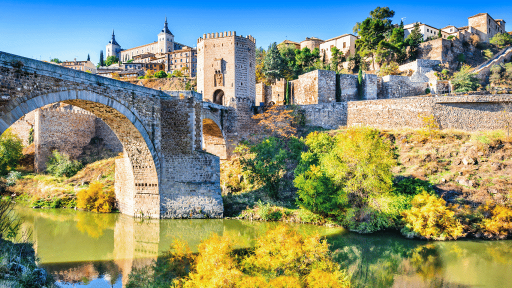 El Puente de Alcántara sobre el río Tajo. Una vista imprescindible que ver en Toledo con el Alcázar al fondo.