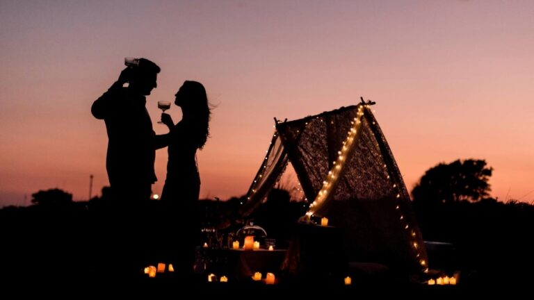 Pareja brindando al atardecer frente a una de las mejores cabañas en los árboles San Valentín 2026.