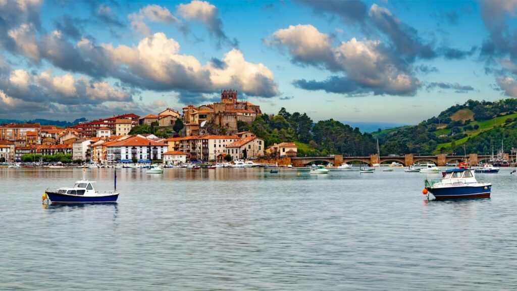 Panorámica de San Vicente de la Barquera con el puente de la Maza, barcas en la ría y la iglesia de Santa María de los Ángeles.
