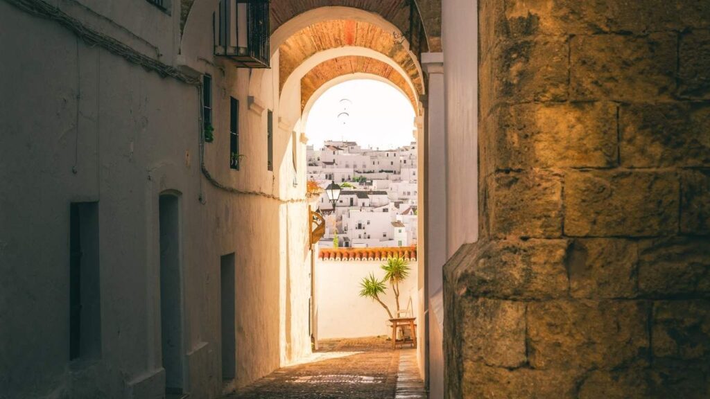 El famoso Arco de las Monjas en Vejer de la Frontera, un pasaje con arcos de piedra que enmarcan las casas blancas al fondo.