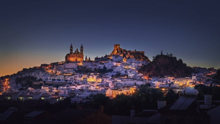 Panorámica de Arcos de la Frontera al atardecer, con la iglesia de Santa María de la Asunción en lo alto del tajo sobre las casas blancas.